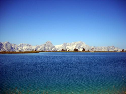 a large body of water with mountains in the background at Haus Löger Apartments Pyhrn Priel in Windischgarsten