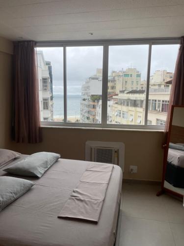 a bedroom with a bed and a view of the ocean at Apartamento Copacabana, Vista para o mar e com garagem in Rio de Janeiro