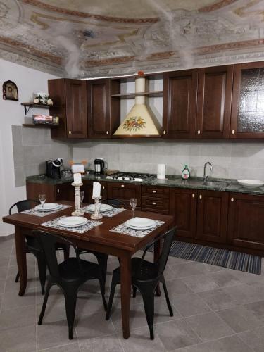 cocina con mesa de madera con sillas y fregadero en La Vecchia Riseria 1, en Novara