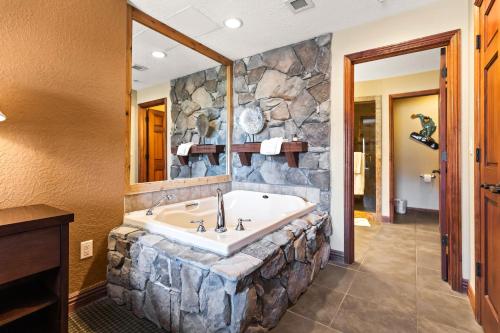 a bathroom with a large tub in a stone wall at Canyons Westgate Resort #4506 in Park City