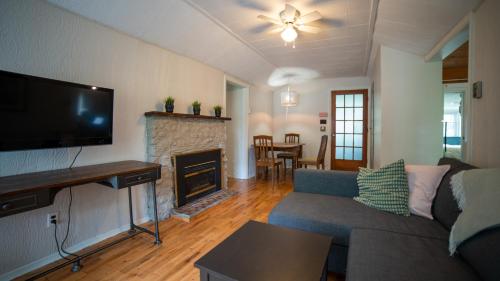 a living room with a couch and a fireplace at Cobblestone Cottages in Sharbot Lake