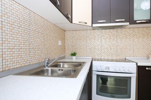 uma cozinha com um lavatório e um fogão em Apartment oslo 4 em Vlorë