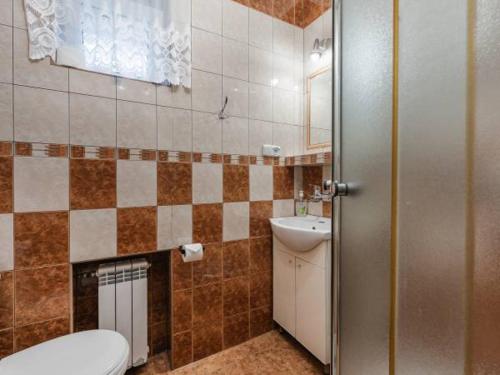 La salle de bains est pourvue de toilettes et d'un lavabo. dans l'établissement Willa Tomek, à Krynica-Zdrój