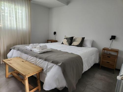 a bedroom with a large bed and a wooden table at CABRAL CENTRO in Rafaela