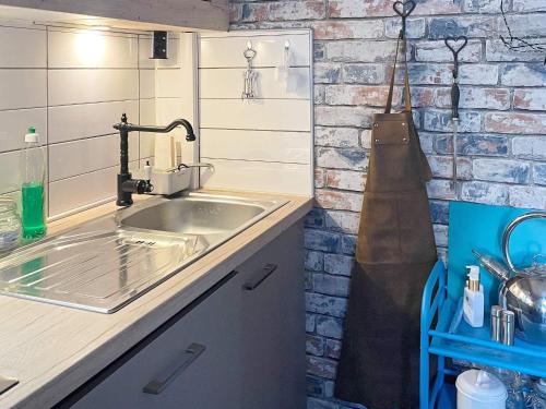 a kitchen with a sink and a brick wall at Holiday home JÖNKÖPING III in Jönköping