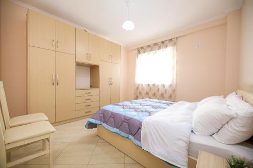 um quarto com uma cama, uma cadeira e uma janela em Apartment oslo 4 em Vlorë