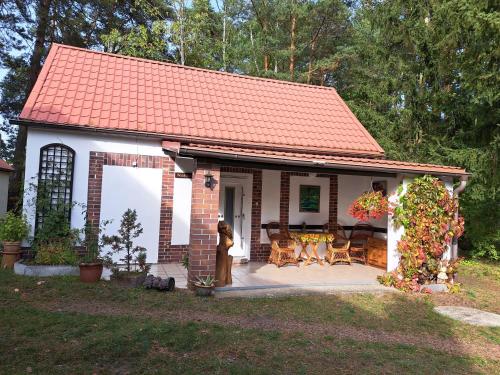 a small house with a patio and a table at Tornower Waldhäusl, perfekt gelegen 60 km vor Berlin, auf der Schwelle zum Spreewald und nahe Tropical Islands 
