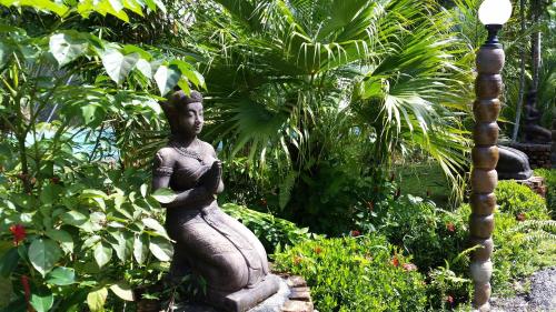 a statue of a woman sitting next to a street light at Hotel Khaosok and Spa in Khao Sok