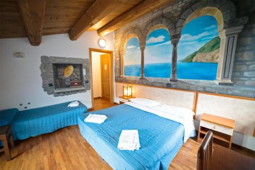 a bedroom with a blue bed and a painting on the wall at Agriturismo Campo Rosso in Civitella di Romagna