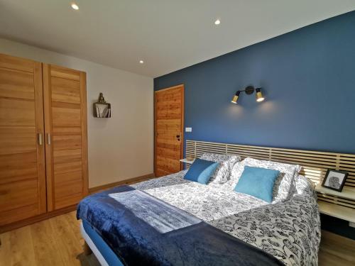 um quarto com uma cama grande e uma parede azul em Le Refuge de Jorance et son spa privatif 5 places en pleine nature em Saint-Julien-du-Pinet
