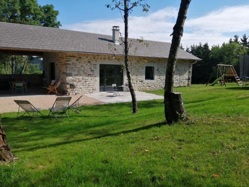 uma casa de pedra com duas cadeiras num quintal em Le Refuge de Jorance et son spa privatif 5 places en pleine nature em Saint-Julien-du-Pinet