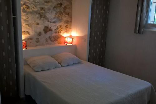 a bedroom with a bed with two pillows on it at Gîte La Charlette in Cheval-Blanc