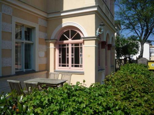 a table and bench in front of a house at Villa Bellevue in Ahlbeck
