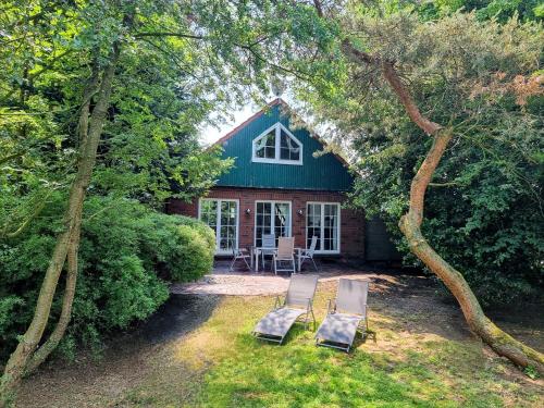 two chairs sitting in front of a house at Ferienwohnungen Sund Ostfriesland in Großefehn 