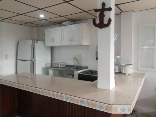 une cuisine avec des placards blancs et un comptoir dans l'établissement San José cerca de las Nuñez casa cerca del Mar, à Santa Elena