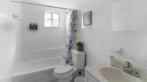 biała łazienka z toaletą i umywalką w obiekcie Gorgeous 2 2 Hospitals Ballpark Downtown Parking w Miami