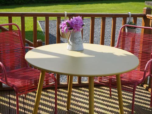 a vase of flowers sitting on a table on a porch at Roe Deer Lodge in Newton Stewart