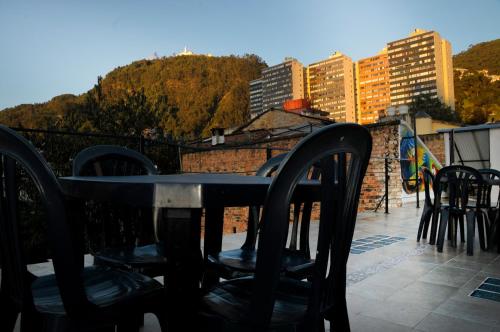une table et des chaises assises au-dessus d'un balcon dans l'établissement Hostal Chorro De Quevedo, à Bogotá