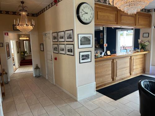 a hallway with a clock on the wall and a counter at Hotell Hertig Karl in Filipstad