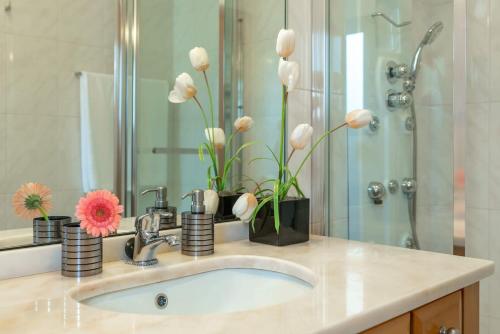 a bathroom sink with a vase of flowers on it at Belo Mar in Arco da Calheta