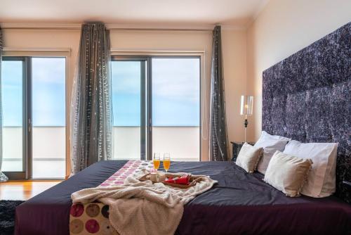 a bedroom with a large bed with a large window at Belo Mar in Arco da Calheta