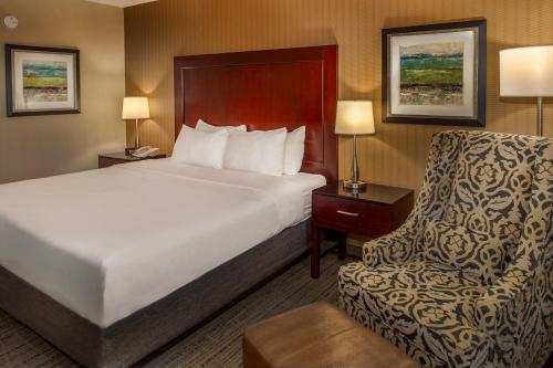 a hotel room with a bed and a chair at Crowne Plaza Hotel St. Louis Airport by IHG in Bridgeton