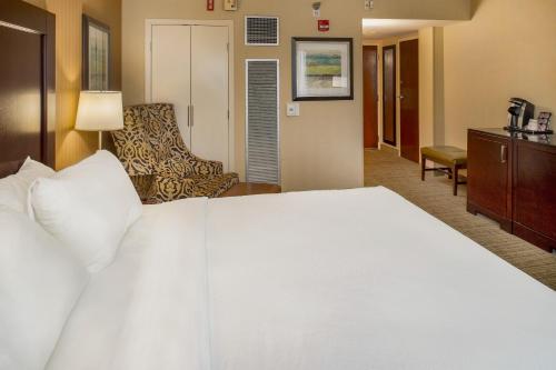 a large white bed in a hotel room at Crowne Plaza Hotel St. Louis Airport by IHG in Bridgeton