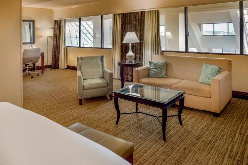 a hotel room with a bed and a couch and a table at Crowne Plaza Hotel St. Louis Airport by IHG in Bridgeton