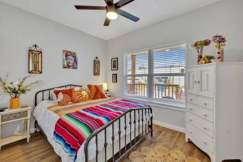 1 dormitorio con 1 cama y ventilador de techo en The Coco House/Lone Star Dist/Jacuzzi/Golf Cart, en San Antonio