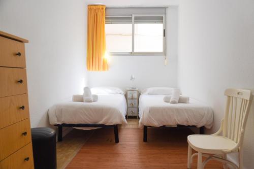 ein Schlafzimmer mit zwei Betten und einem Fenster in der Unterkunft Caletillas Sun & Sea in Araya