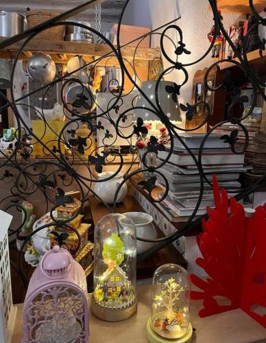 a table with glass vases and a shelf with books at A Casa da Paola in Caccamo