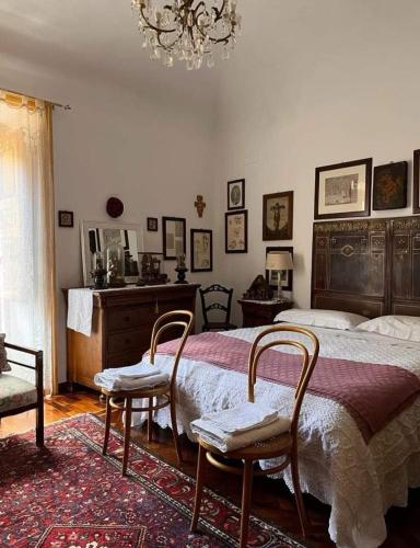 um quarto com uma cama, 2 cadeiras e um lustre em A Casa da Paola em Caccamo