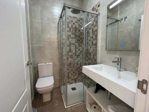 een badkamer met een toilet, een wastafel en een douche bij Piso deluxe en pleno centro - San Juan 39 in Sanlúcar de Barrameda