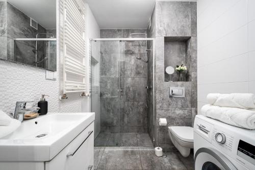 La salle de bains est pourvue d'une douche, d'un lavabo et de toilettes. dans l'établissement Apart D&K Free Parking Cybernetyki 2E, à Varsovie