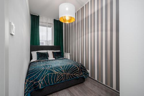 1 dormitorio con cama y pared a rayas en Apart D&K Free Parking Cybernetyki 2E, en Varsovia