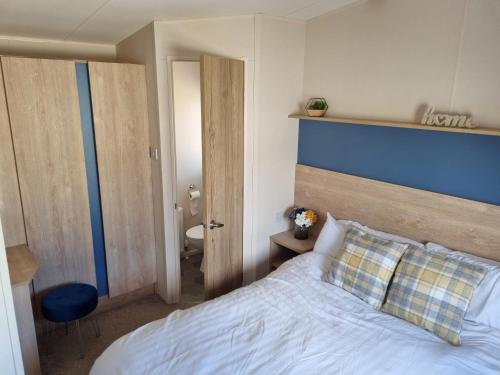 a bedroom with a bed with a blue headboard at 58 Lancaster crescent in Tattershall