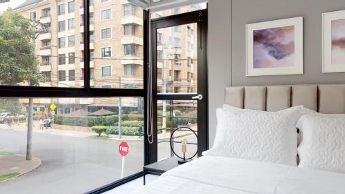 um quarto com uma cama e uma janela com um sinal de stop em Lujoso apto de 2 habitaciones amplio con excelente vista em Bogotá