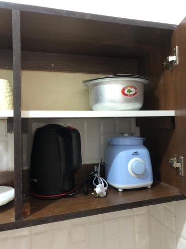 a shelf with a microwave and a toaster and a toaster at Chillhaushomes in Mombasa