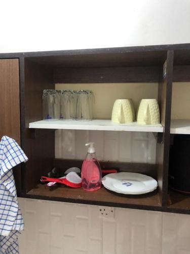 a shelf in a kitchen with plates and dishes at Chillhaushomes in Mombasa