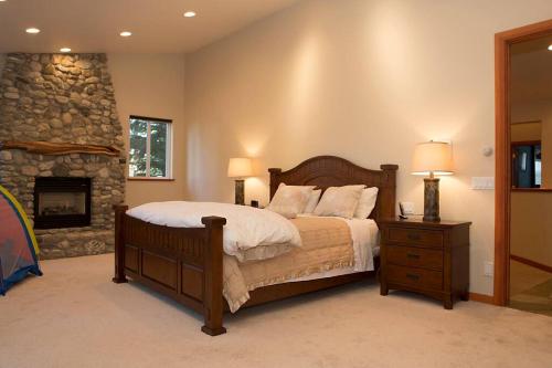 a bedroom with a bed and a stone fireplace at Big Luxury South Lake Tahoe Home in South Lake Tahoe