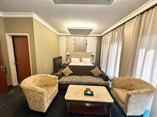 a hotel room with a bed and two chairs at Padova Hotel in Beirut