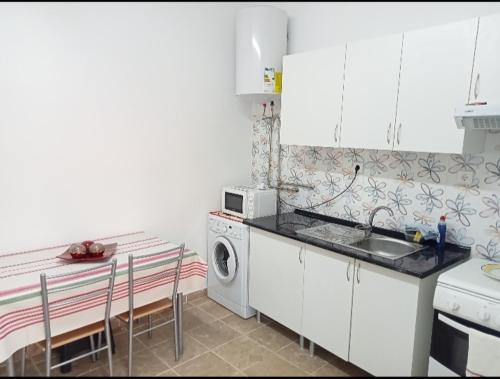 a kitchen with a sink and a washing machine at Quarto duplo in Gradil