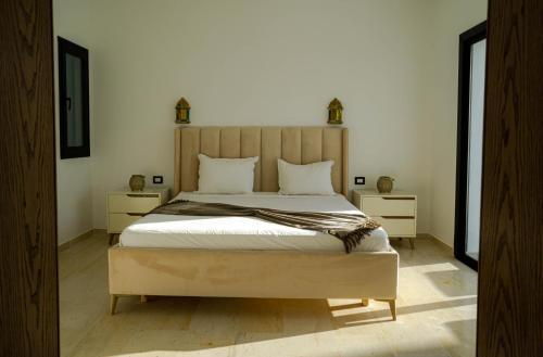 DjerbaにあるVilla des deux oliviers Djerbaのベッドルーム1室(大型ベッド1台、ナイトスタンド2台付)