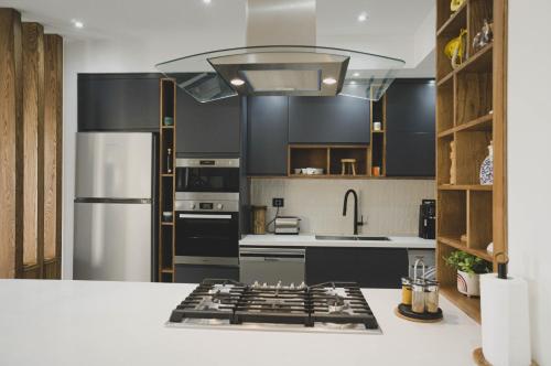 a kitchen with black cabinets and a stainless steel refrigerator at Villa des deux oliviers Djerba in Djerba