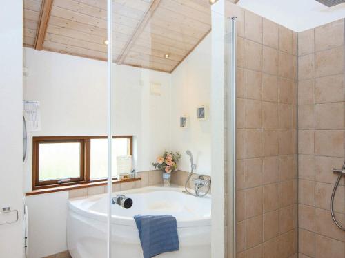 a bathroom with a bath tub and a shower at Three-Bedroom Holiday home in Ulfborg 5 in Thorsminde