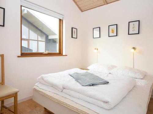 a white bed in a room with a window at Three-Bedroom Holiday home in Ulfborg 5 in Thorsminde