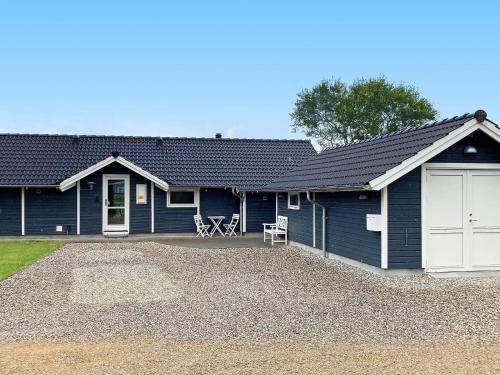 uma casa azul com uma garagem branca em 6 person holiday home in Vinderup em Vinderup