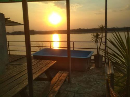 a bath tub sitting on a dock with the sunset at Buena Vista in Salto