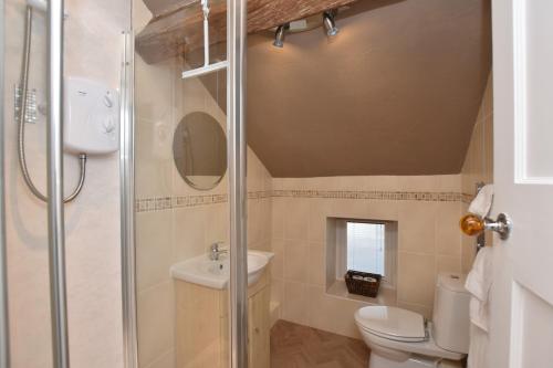 La salle de bains est pourvue d'une douche et de toilettes. dans l'établissement Lazy Days Cottage, à Barrowford