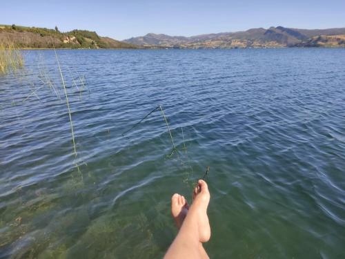 a persons legs in the water while holding a fishing rod at La cabaña de sol in Aquitania